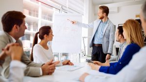 B2B sales manager splitting time between personal selling and team coaching, illustrating the player-coach model challenges and time allocation conflicts.